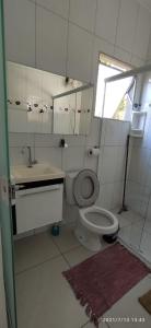 een badkamer met een toilet, een wastafel en een raam bij Chale da Dalva in Ubatuba