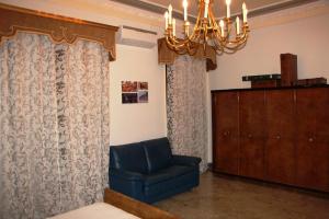 un soggiorno con una sedia blu e un lampadario a braccio di Giardinetto Papale, centralissimo a Caltagirone