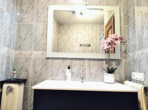 a bathroom with a sink and a mirror at La casa de Tentenecio in Salamanca