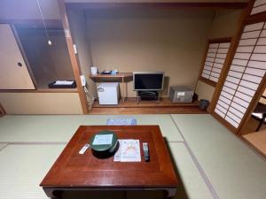 a living room with a table and a television at Iso Tokei - Vacation STAY 61892v in Kanayama
