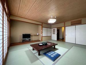 ein Wohnzimmer mit einem Tisch und einem TV in der Unterkunft Iso Tokei - Vacation STAY 61860v in Kanayama