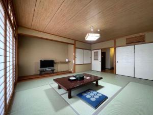 a living room with a table and a tv at Iso Tokei - Vacation STAY 61860v in Kanayama