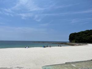 金山にあるIso Tokei - Vacation STAY 61909vの白浜に立つ人々 +8枚の写真
