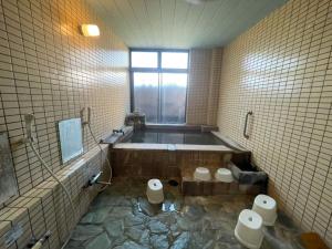 a bathroom with a bath tub and two toilets at Iso Tokei - Vacation STAY 61909v in Kanayama
