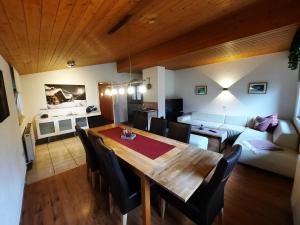 a dining room and living room with a table and chairs at Chalet Landhaus Einsiedler in Sankt Gallenkirch