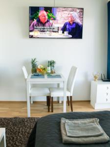 a dining room with a table and a tv on the wall at City center brand new studio, parking in Oulu