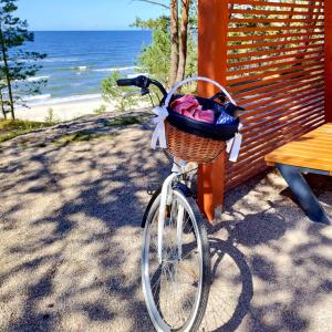 uma bicicleta com um cesto estacionado ao lado de uma mesa em Apartamenty Amarel - Wilk Morski em Stegna