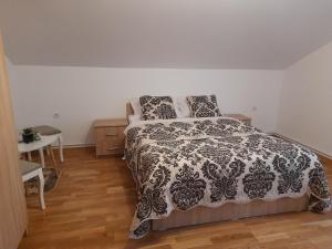 a bedroom with a bed with a black and white comforter at Pensiunea Deny şi Dany in Ribiţa