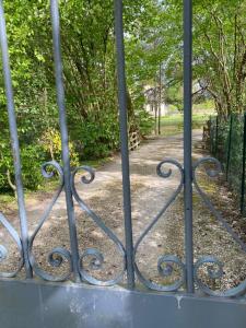 an iron gate with a path in a park at Château de la Coudraie in Changé