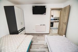 a small room with two beds and a tv at CUDERLAND -CUKR in Kobarid