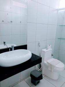 Baño blanco con lavabo y aseo en Pousada Tambaú, en João Pessoa