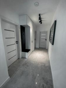 an empty hallway with white walls and white doors at NADJEZIORNA LUX 3 in Ełk
