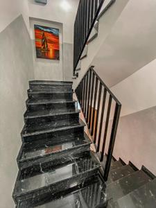 a staircase in a house with a painting on the wall at NADJEZIORNA LUX 3 in Ełk