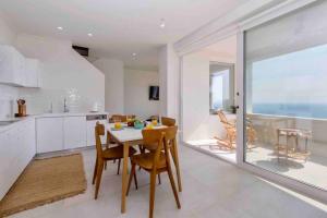 a kitchen and dining room with a table and chairs at anaera in Pelekas