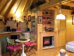 a kitchen and living room with a fireplace at La Cabane de Cécile-la Hutte in Étretat