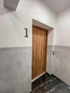 a door in a room with a number one on the wall at NADJEZIORNA LUX 1 in Ełk