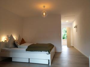 a bedroom with a white bed and a hallway at Claar Ferienwohnung Lindau Bodensee in Lindau