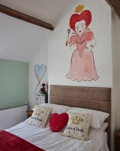 a bedroom with a bed with two hearts on the wall at Violets Wonderland Cottage in Llandudno
