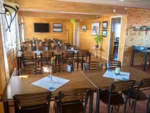 a room full of tables and chairs in a restaurant at Kaikanten Rorbuer - Røst in Røst +22 photos