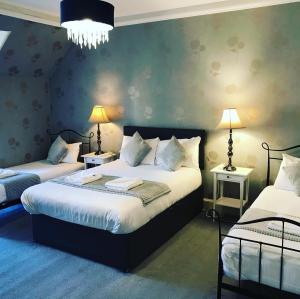 1 Schlafzimmer mit 2 Betten und 2 Lampen in der Unterkunft Ardenlee Guest House in Edinburgh