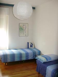 een slaapkamer met 2 aparte bedden en een kroonluchter bij Bed and Breakfast Relax in Trento