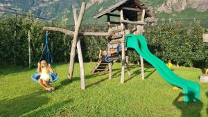 dos niños jugando en un columpio en un patio en Villa Trogerhof, en Ora - Auer