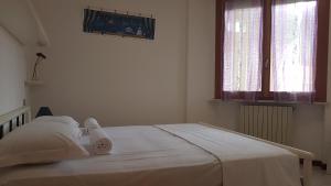 a white bed in a white room with towels on it at G -Suite SENIGALLIA in Senigallia +8 photos