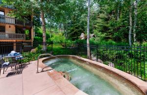 a hot tub in a yard next to a fence at Interlude Condominiums 3-Bedroom Unit 308 in Snowmass Village