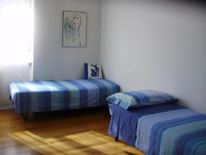 een slaapkamer met 2 bedden en een schilderij aan de muur bij Bed and Breakfast Relax in Trento