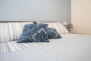 Una cama con almohadas azules y blancas. en B&B La Piazzetta en Pompei