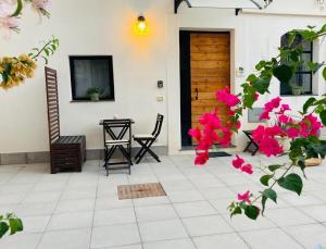 a patio with pink flowers and a door at Il Limone Holiday Home Siracusa in Siracusa