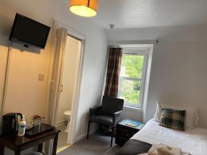a hotel room with a bed and a chair and a window at Richmond House Hotel in Fort Augustus