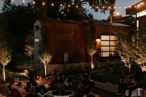 un grupo de personas sentadas en un patio por la noche en Ironwood Grove, Tiny House Hotel, en Nashville