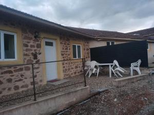 a house with a table and chairs in front of it at Gîte campagne in Cours la Ville