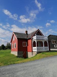 ein rotes und weißes Haus am Straßenrand in der Unterkunft Sommerstue Hessdalen in Ålen