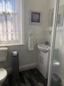 a white bathroom with a toilet and a sink at Cranstone Hotel in Blackpool