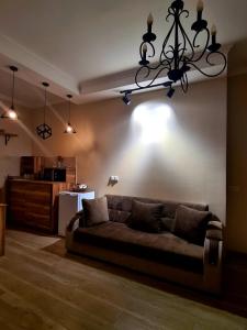 ein Wohnzimmer mit einem Sofa und einem Kronleuchter in der Unterkunft Apartments Baqari Inn in Kazbegi