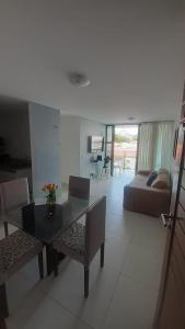 sala de estar con mesa, sillas y sofá en APARTAMENTO TEMPORADA - CABO BRANCO, en João Pessoa