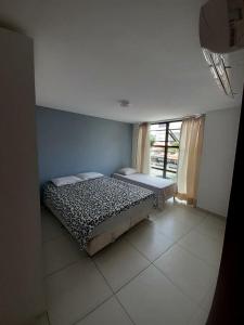 1 dormitorio con 1 cama en una habitación con ventana en APARTAMENTO TEMPORADA - CABO BRANCO, en João Pessoa