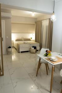 a white bedroom with a bed and a table at Sunset brand new luxury apt with pool & sea view in Karpathos Town
