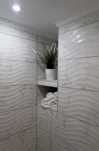 baño con estante con toallas y planta en Sunset brand new luxury apt with pool & sea view en Kárpatos