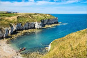 un grupo de personas en una playa junto al océano en HARBOUR VIEW HOLIDAY LET - Entire 3 Bedroom Maisonette With Spectacular Harbour And Sea Front Views Sleeps 5, en Bridlington