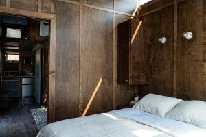 a bedroom with a bed and a wooden wall at Ironwood Grove, Tiny House Hotel in Nashville