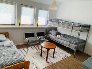 a bedroom with two bunk beds and a table and a stool at Luhne Boutique Pension in Luhne