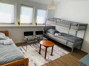 a bedroom with two bunk beds and a table and a stool at Luhne Boutique Pension in Rotenburg an der Wümme