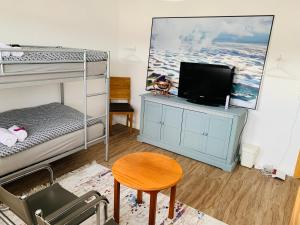 - une chambre avec des lits superposés, une télévision et une table dans l'établissement Luhne Boutique Pension, à Luhne