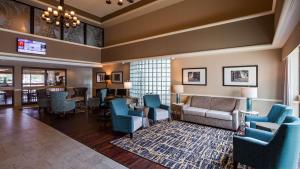 a lobby with blue chairs and a waiting room at Best Western East Towne Suites in Madison