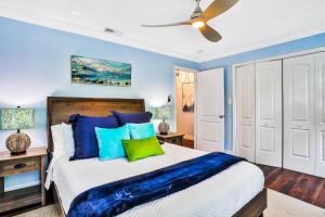 a bedroom with a large bed with blue walls at Flamingo Cottage in New Smyrna Beach