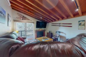 Una sala de estar con un sofá de cuero y una chimenea. en Valley Perch, en Sun Valley
