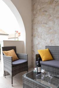 - une terrasse avec 2 chaises et une table avec une bouteille de vin dans l'établissement Apartment Maestral, à Mlini
